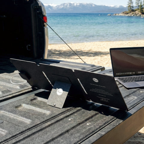  Emergency Solar Laptop and Phone Charger on the back of a truck by mountains and lake in background